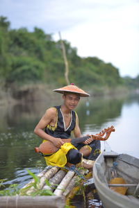 Man holding boat in lake