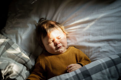 Close-up of cute baby sleeping on bed at home