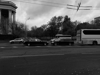 Cars on road in city against sky