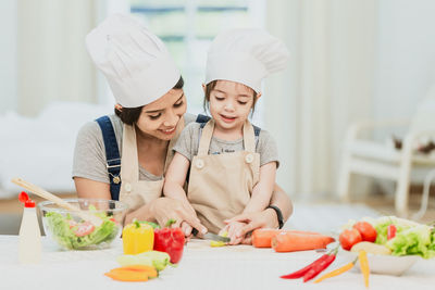 Midsection of woman having food in kitchen