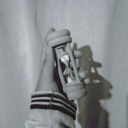 Close-up of woman holding hands against wall