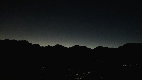 Scenic view of silhouette mountains against sky at night