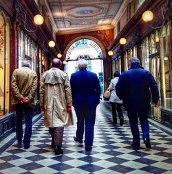 Rear view of people walking in tunnel