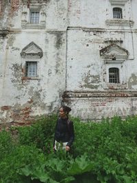 Full length of woman standing by old building