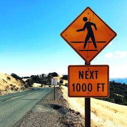 Road sign against blue sky