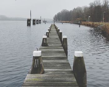 Wooden pier over lake against sky