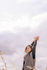 Low angle view of woman standing against sky