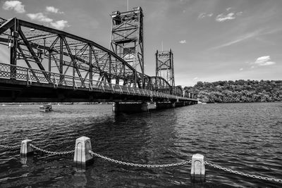 Lift bridge over river against sky