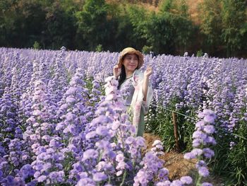 Portrait of woman with purple flowers on plants