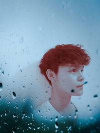 Portrait of a boy looking away in rain