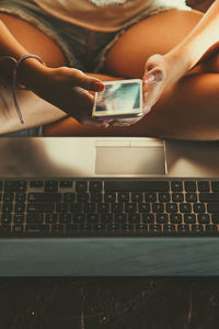 Midsection of woman using laptop