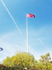 Low angle view of flag against blue sky