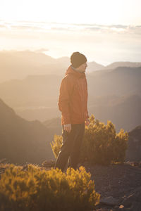 Traveller with smile enjoys view from pico ruivo, highest mountain on portuguese island of madeira