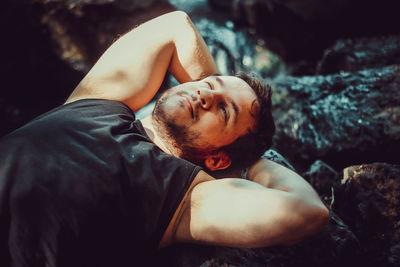 Portrait of man lying on rock
