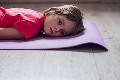 Tired girl lies on mat after workout at home.  the concept of fatigue and psychological burnout