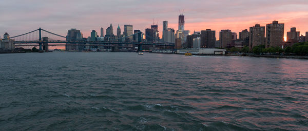 View of suspension bridge in city at sunset