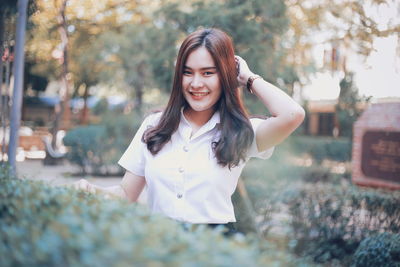 Portrait of smiling young woman standing outdoors