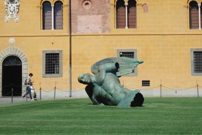 Statue against building in city