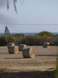 Hay bales on field against sky