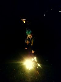 Young woman in illuminated light at night