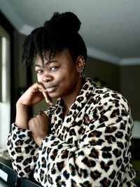 Portrait of young woman looking away while sitting at home