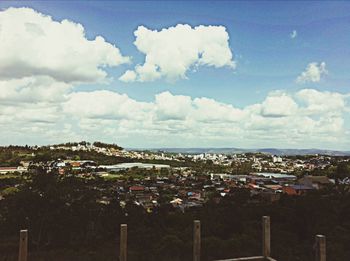 View of cityscape against cloudy sky