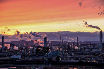 Illuminated factory against sky during sunset 