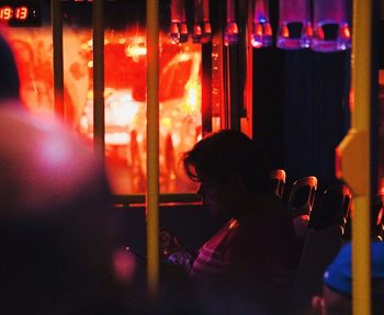 Rear view of woman looking at illuminated restaurant