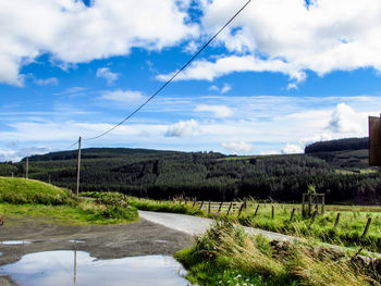 Scenic view of field against cloudy sky