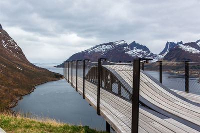 Scenic view of lake by snowcapped mountains against sky