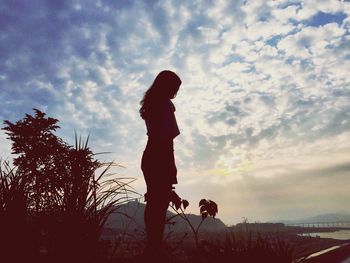 Side view of silhouette people standing on mountain against cloudy sky