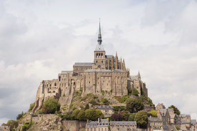 Low angle view of historical building against cloudy sky