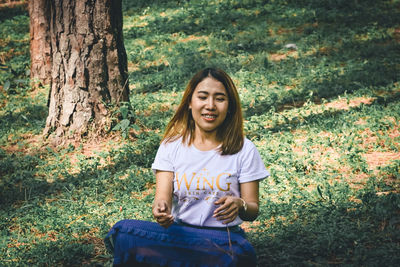 Portrait of smiling young woman standing on field