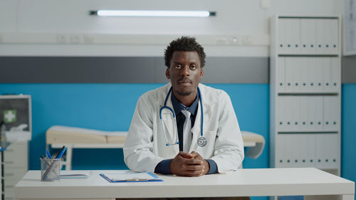 Mid adult man sitting on table