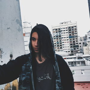 Young woman standing against buildings in city