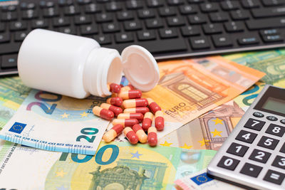 Close-up of pills and calculator on blueprint