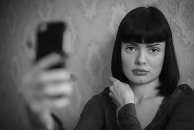 Portrait of woman photographing with mobile phone