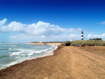 Scenic view of beach against cloudy sky