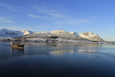 Scenic view of lake and mountains against blue sky