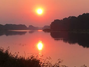 Scenic view of lake against orange sky