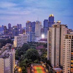 Illuminated modern buildings in city against sky