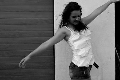 Young woman standing against wall