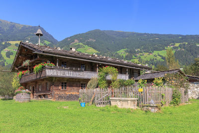 Built structure on grassy field by houses against sky