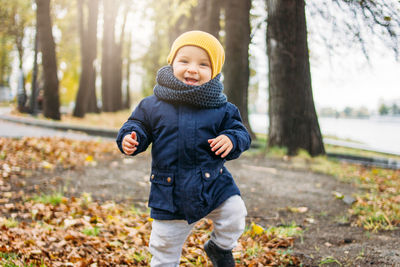 Portrait of cute baby boy standing in park