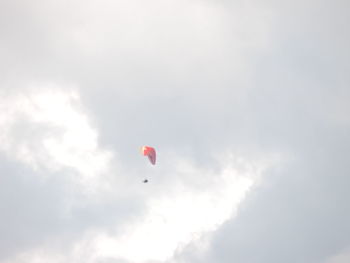 Low angle view of person paragliding against sky