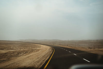 Country road against sky