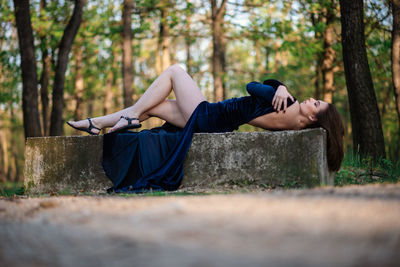 Side view of young woman lying down on land