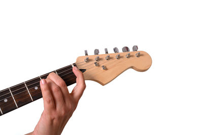 Midsection of man playing guitar against white background