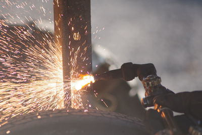 Cropped hand welding metal at night