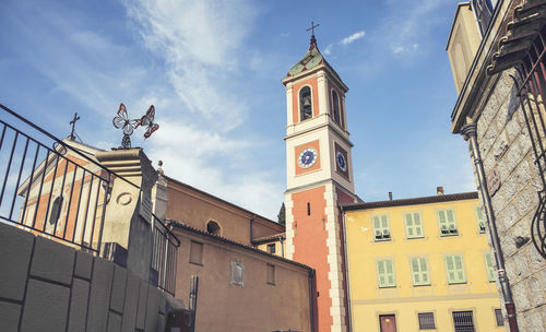 Low angle view of clock tower amidst buildings in city